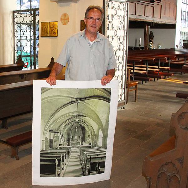 Gregor Mauel zeigt ein historisches Foto der Pfarrkirche St. Peter Zingsheim.