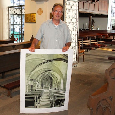 Gregor Mauel zeigt ein historisches Foto der Pfarrkirche St. Peter Zingsheim.