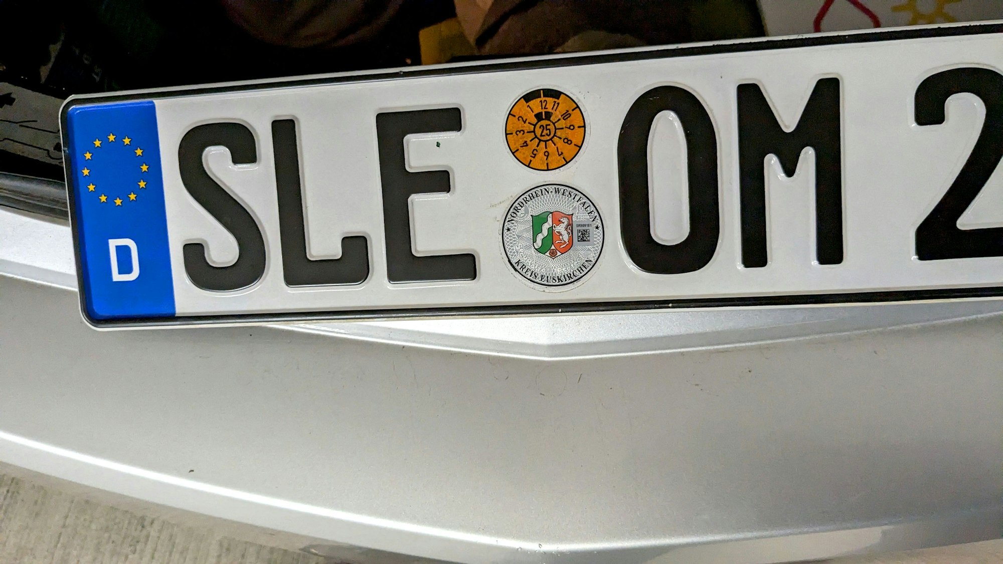 Ein Kennzeichen mit der Aufschrift „SLE“ liegt auf einem Auto.