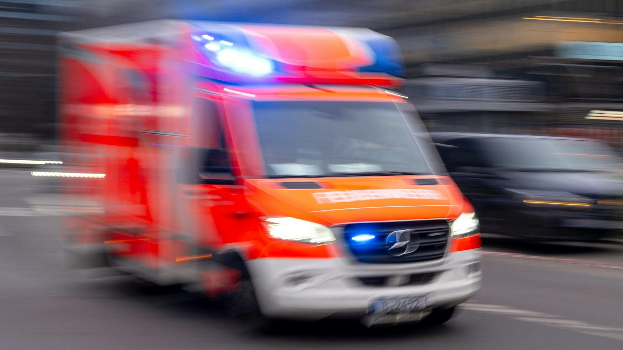 Ein Rettungswagen der Feuerwehr fährt mit Blaulicht zum Einsatz.