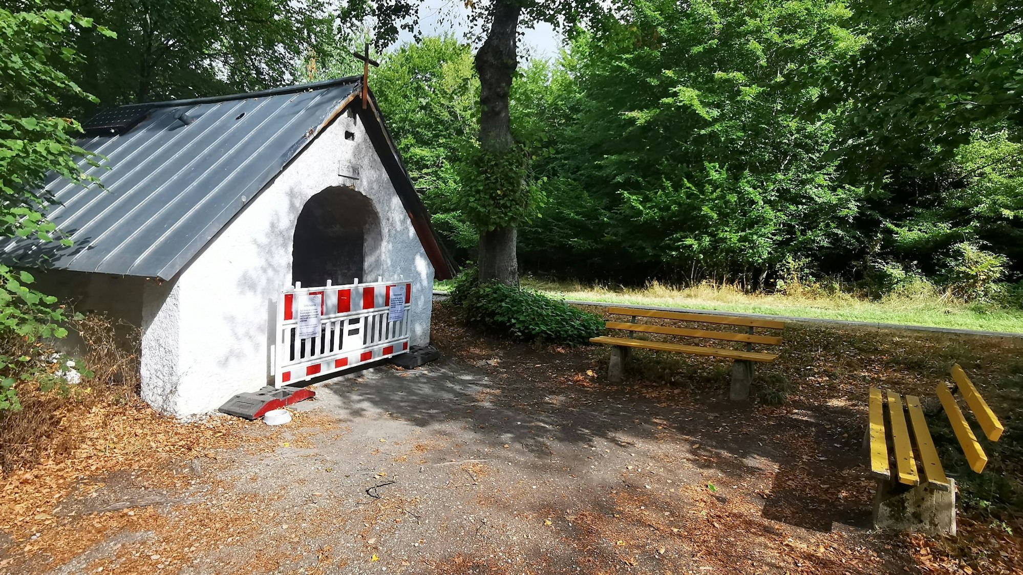 Archivbild der Waldkapelle Decke Tönnes im Münstereifeler Wald, hier vom Ordnungsamt wegen Waldbrandgefahr gesperrt. Zwei gelbe Bänke stehen vor der Kapelle.