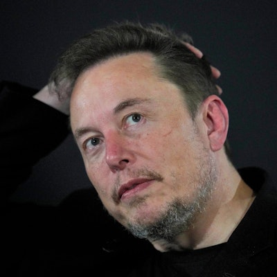 Bild von Elon Musk, der sich mit einer Hand über den Kopf fährt.