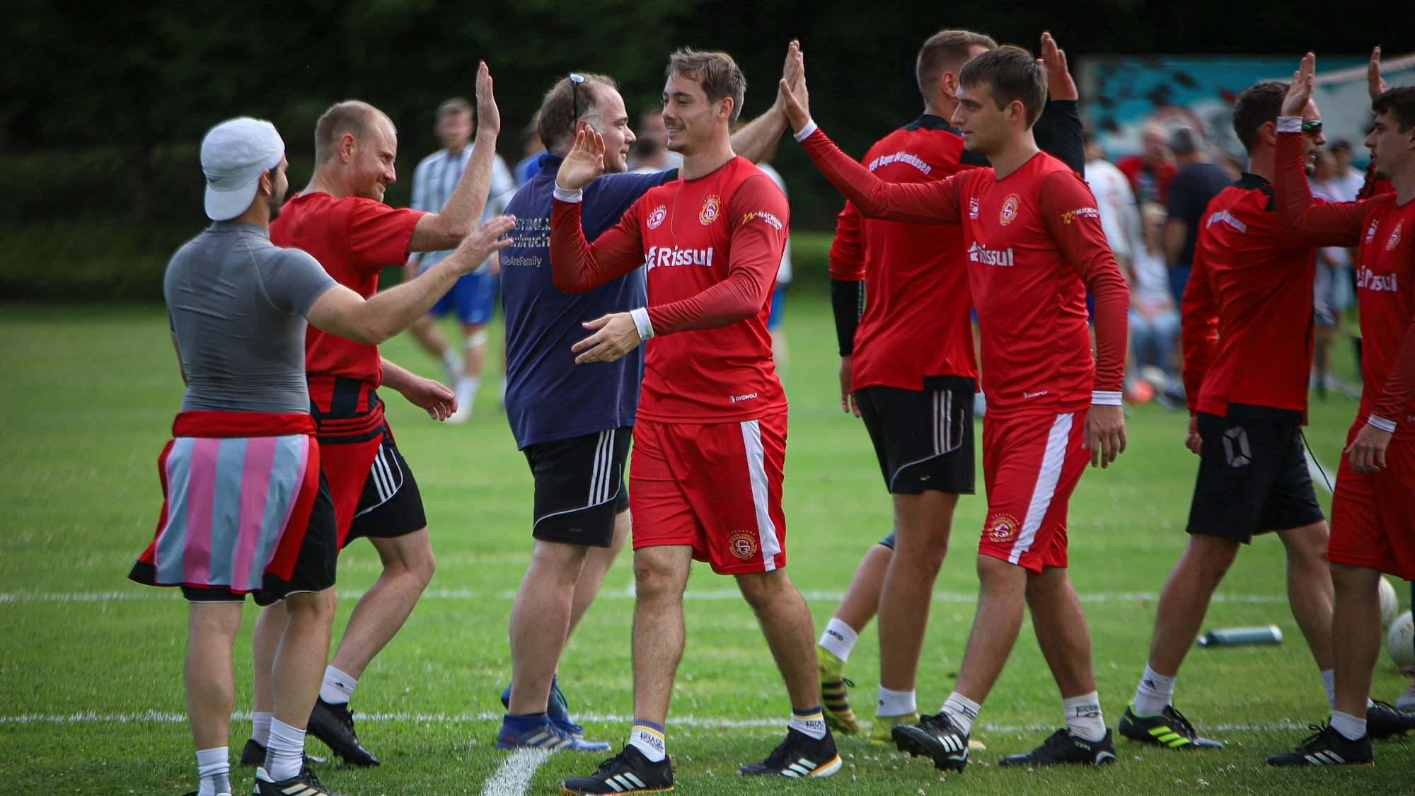 Die Spieler von Bayer 04 Leverkusen und SG Novo Hamburgo geben sich nach dem Spiel High Fives.