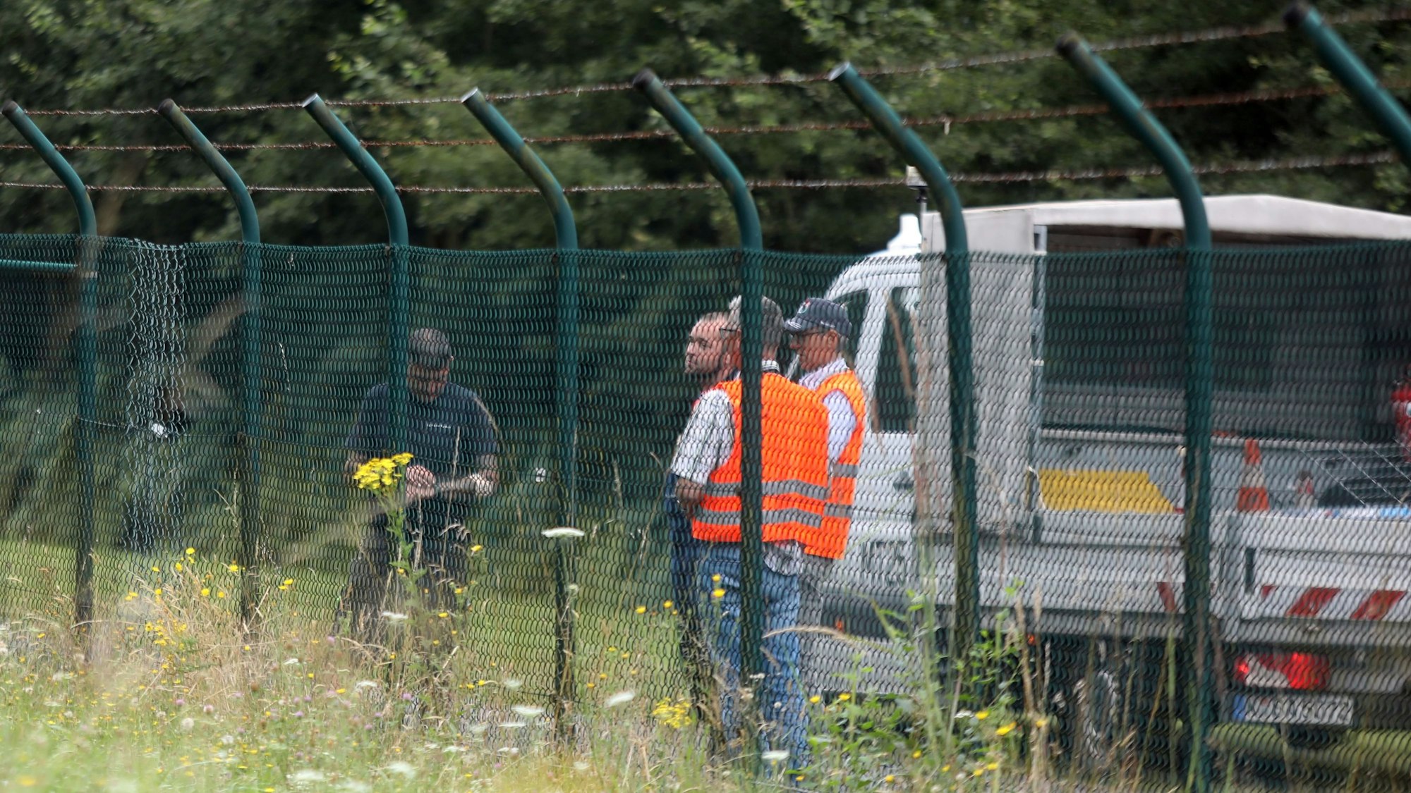 Mitarbeiter des Flughafens sichern den beschädigten Zaun: Hier hatten sich fünf Aktivisten unbefugt Zutritt verschafft und den Flugbetrieb lahmgelegt.