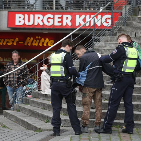 Polizisten kontrollieren einen Mann auf dem Wiener Platz.