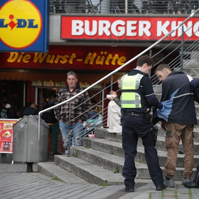 Polizisten kontrollieren einen Mann auf dem Wiener Platz.