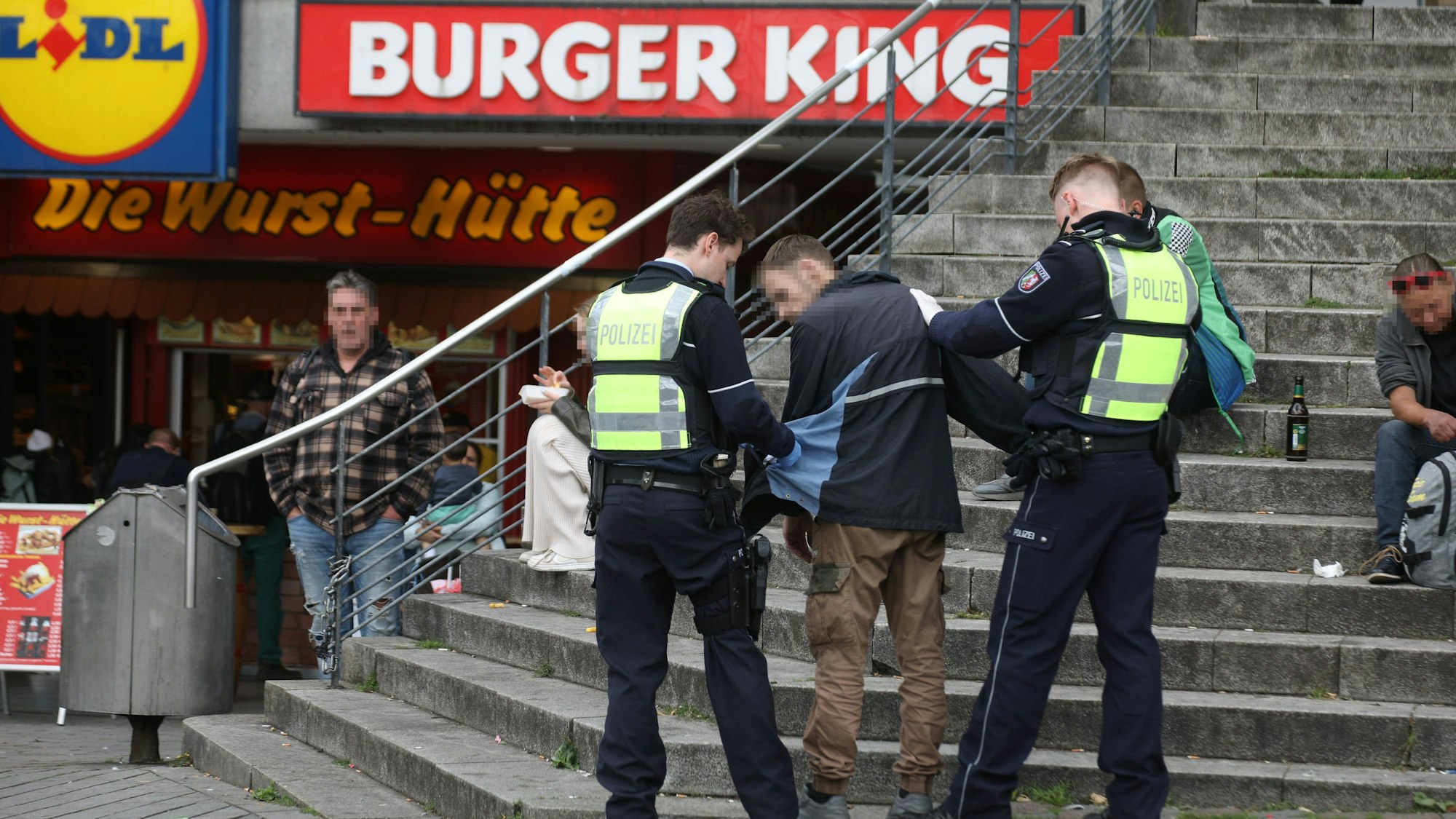 Polizisten kontrollieren einen Mann auf dem Wiener Platz.