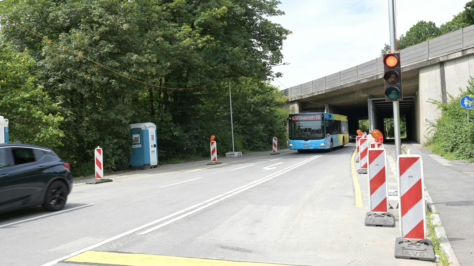 Ein Bus fährt unter der einspurig geöffneten Durchfahrt der A4-Brücke in Untereschbach hindurch, im Vordergrund ist eine rote Ampel zu sehen.