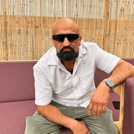 Rapper Xatar sitzt auf einer Außenlounge