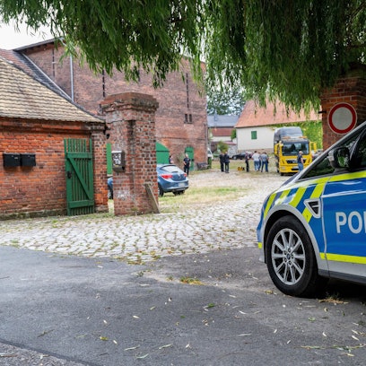 Ein Polizeiauto steht vor dem Rittergut des früheren AfD-Vorsitzenden von Sachsen-Anhalt, Poggenburg.