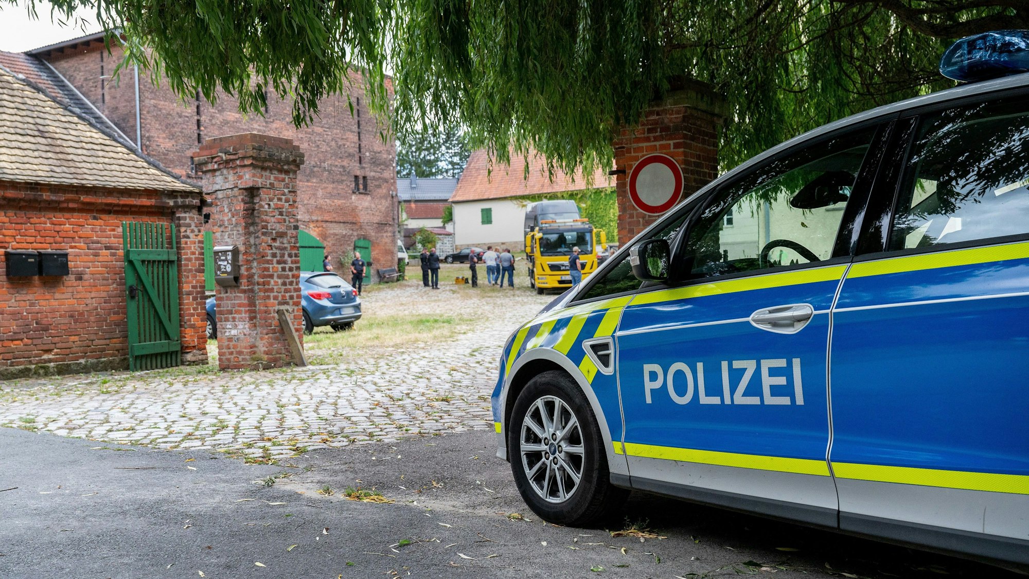 Ein Polizeiauto steht vor dem Rittergut des früheren AfD-Vorsitzenden von Sachsen-Anhalt, Poggenburg.