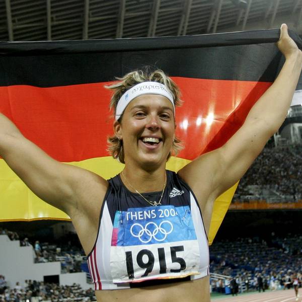 Steffi Nerius breitet eine Deutschlandflagge über ihrem Kopf aus.