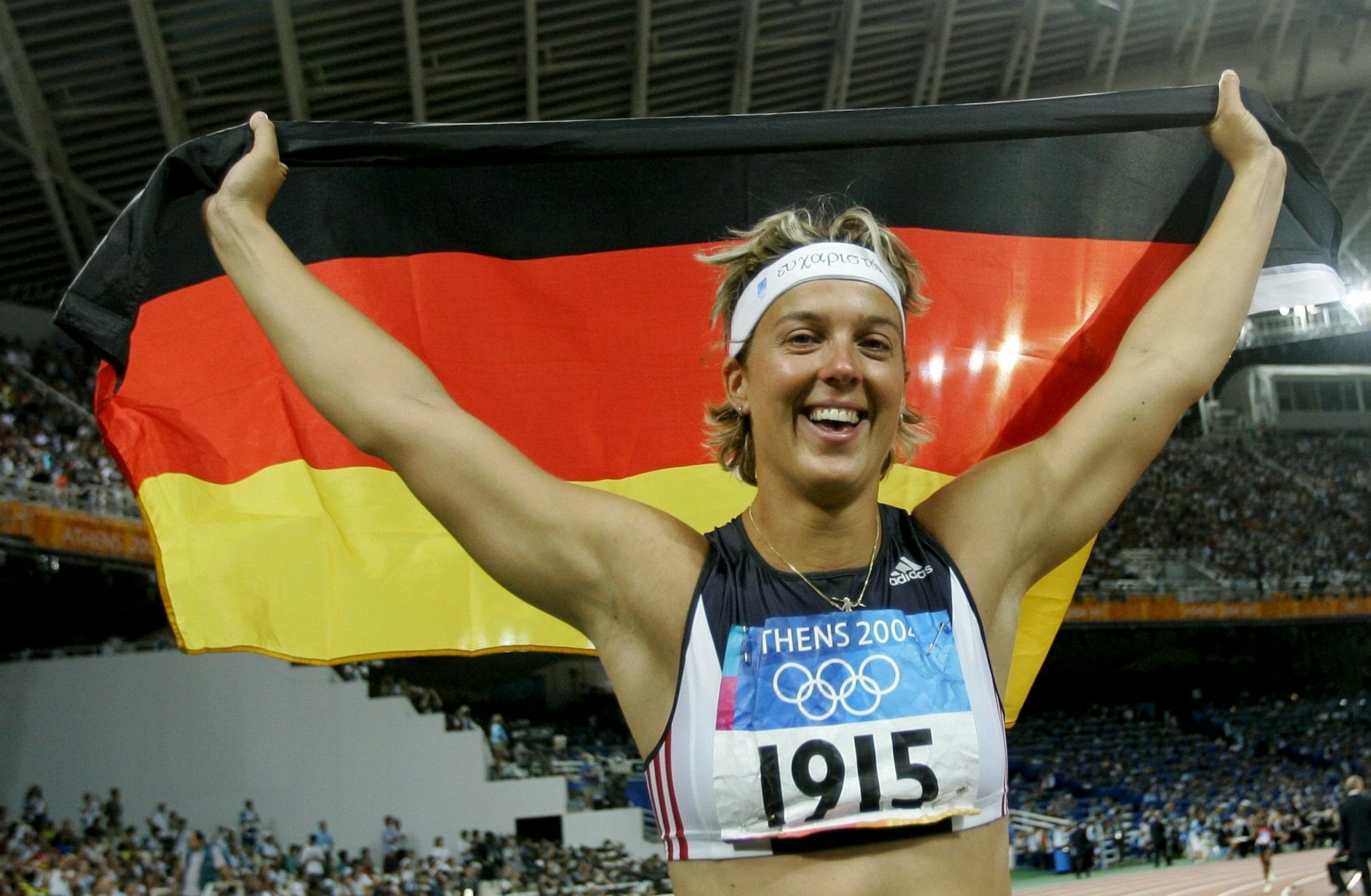 Steffi Nerius breitet eine Deutschlandflagge über ihrem Kopf aus.