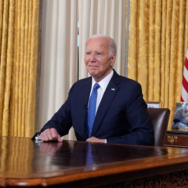 US-Präsident Joe Biden sitzt im Oval Office im Weißen Haus vor einer US-amerikanischen Flagge und blickt vor einer Rede in die Kamera.