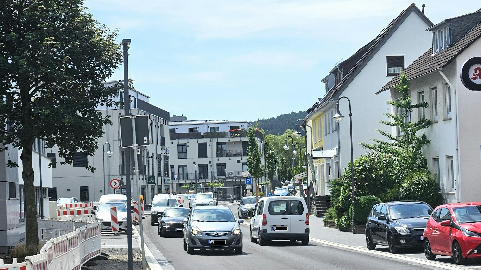 Blick in die neu gestaltete Straße, auf der Autos unterwegs sind.