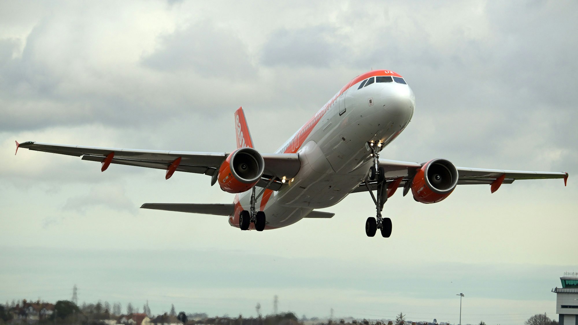 Ein Airbus A320 der britischen Fluggesellschaft Easyjet im Landeanflug auf einen Flughafen. Die Maschine ist markant in orange und weiß lackiert. (Symbolbild)