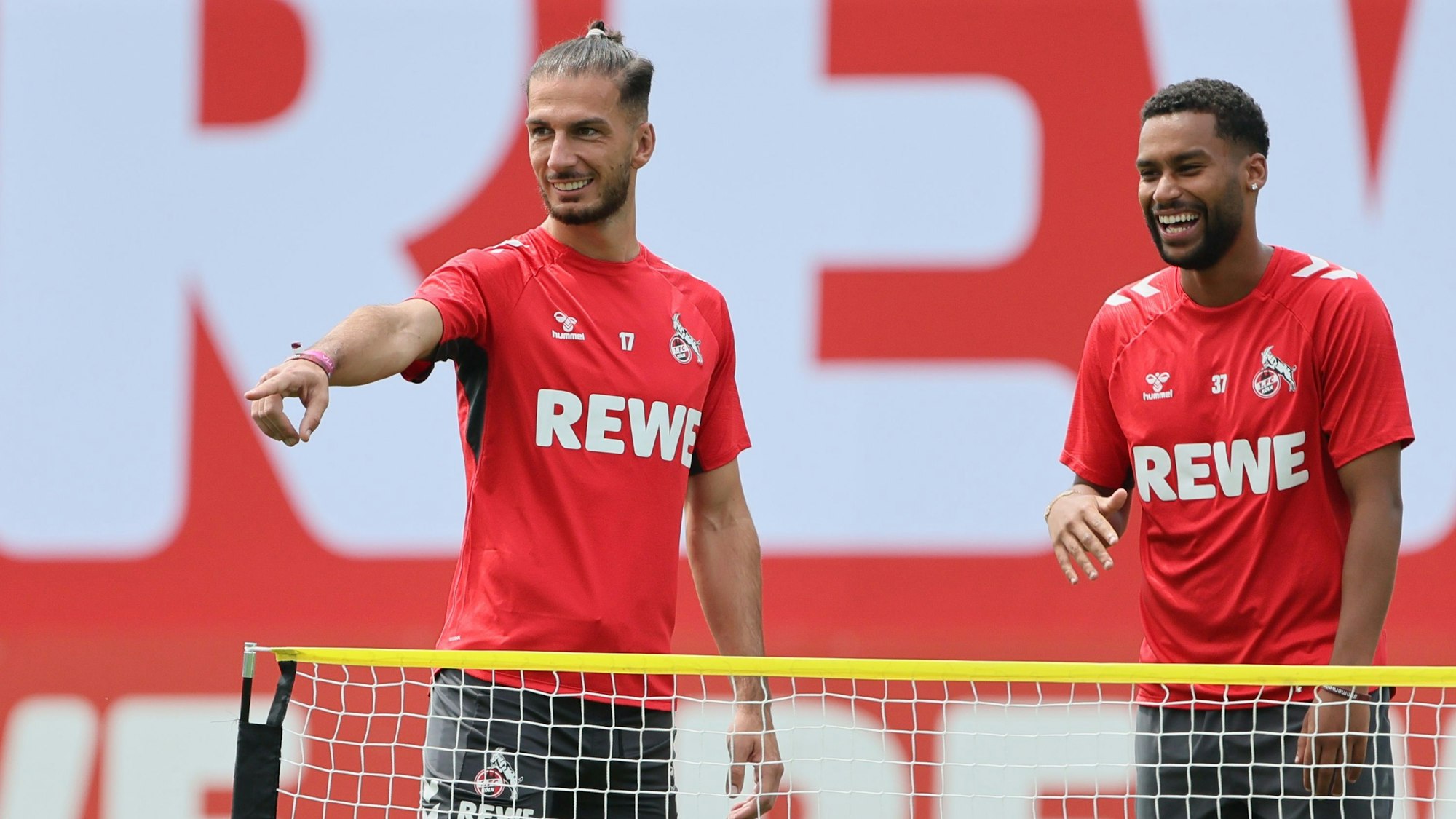 Leart Pacarada (l.) und Linton Maina vom 1. FC Köln lachen auf dem Trainingsplatz in Bad Waltersdorf.