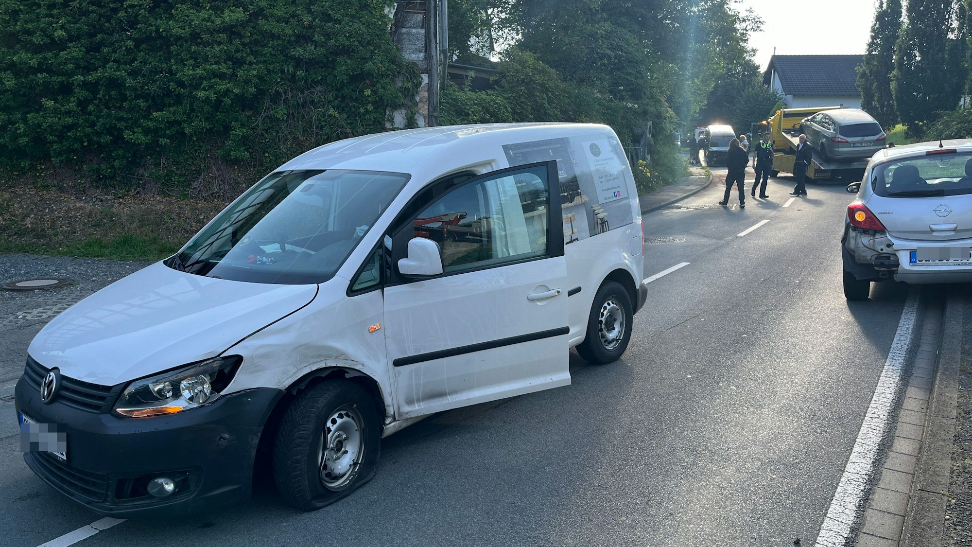 Ein Caddy steht in Teilen auf der Gegenfahrspur, im Hintergrund weitere, am Unfall beteiligte Fahrzeuge von Abschleppunternehmern aufgeladen