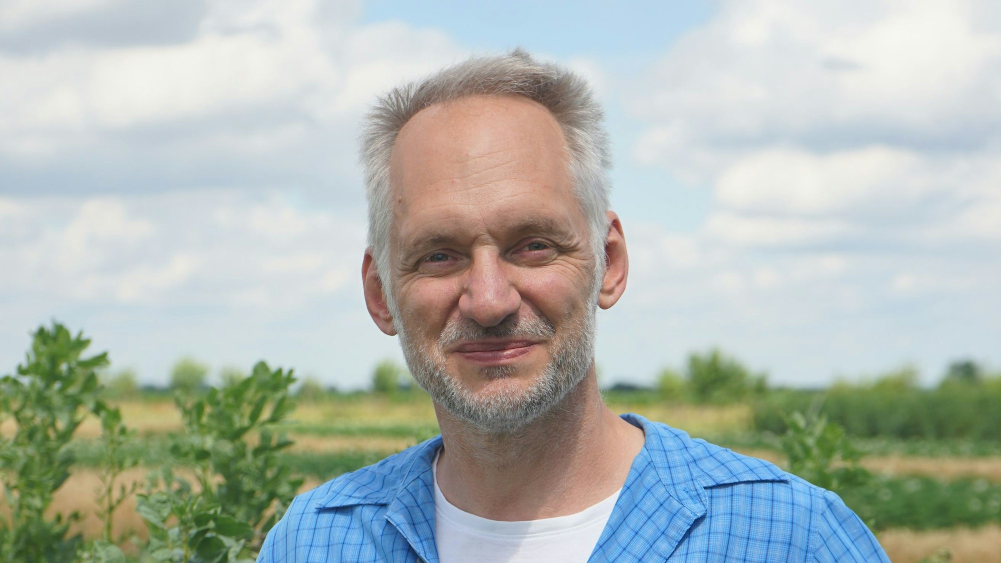 Dr. Gregor Heine vor einem Feld.