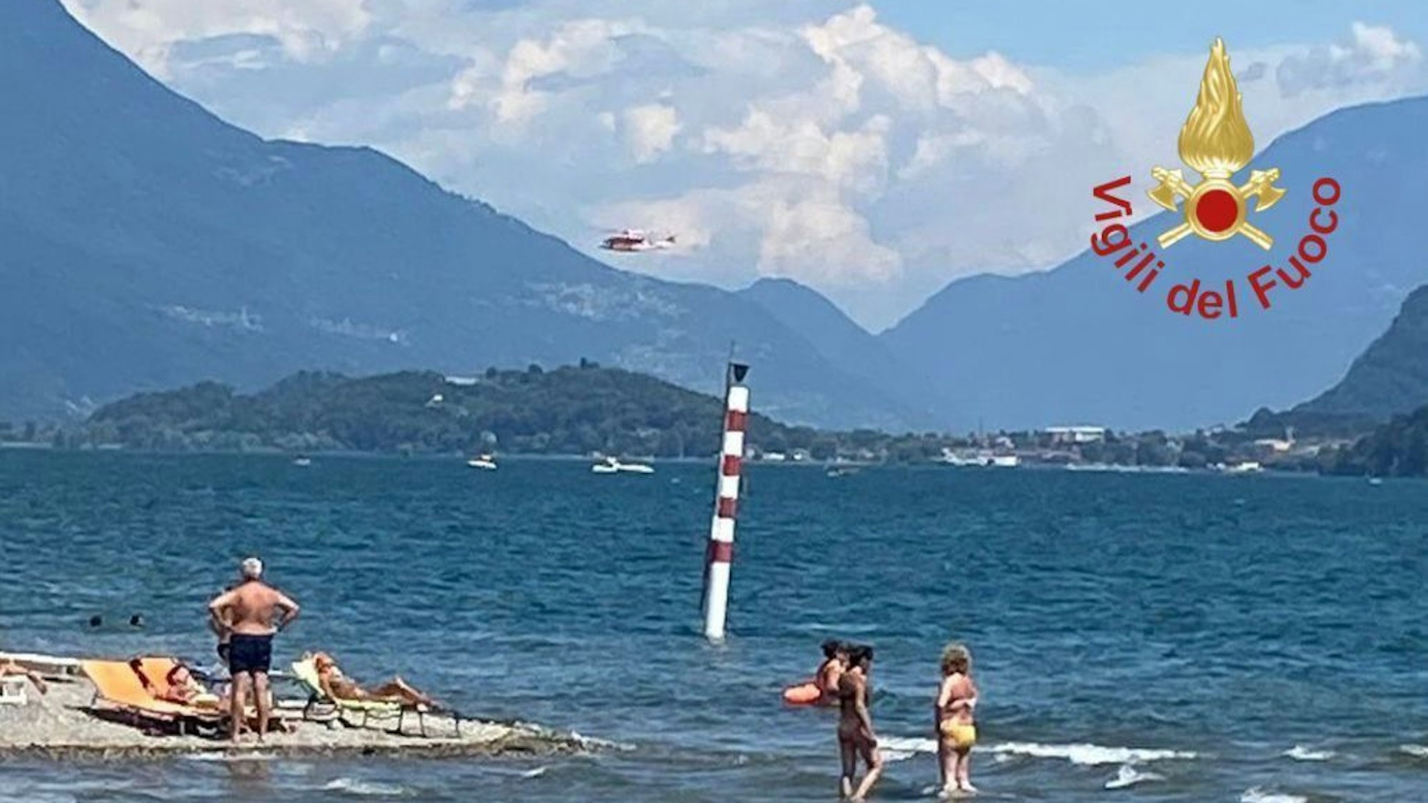 Ein Hubschrauber der italienischen Feuerwehr fliegt über den Comer See.