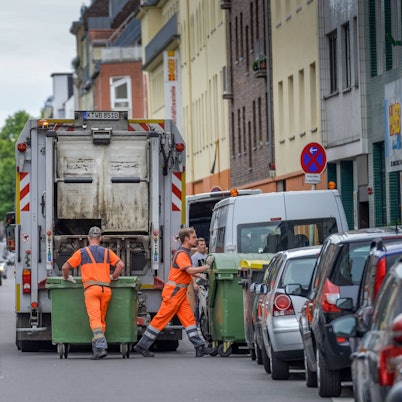 Müllwerker der Kölner Abfallwirtschaftsbetriebe (AWB) bei der Abholung von Müllcontainern.