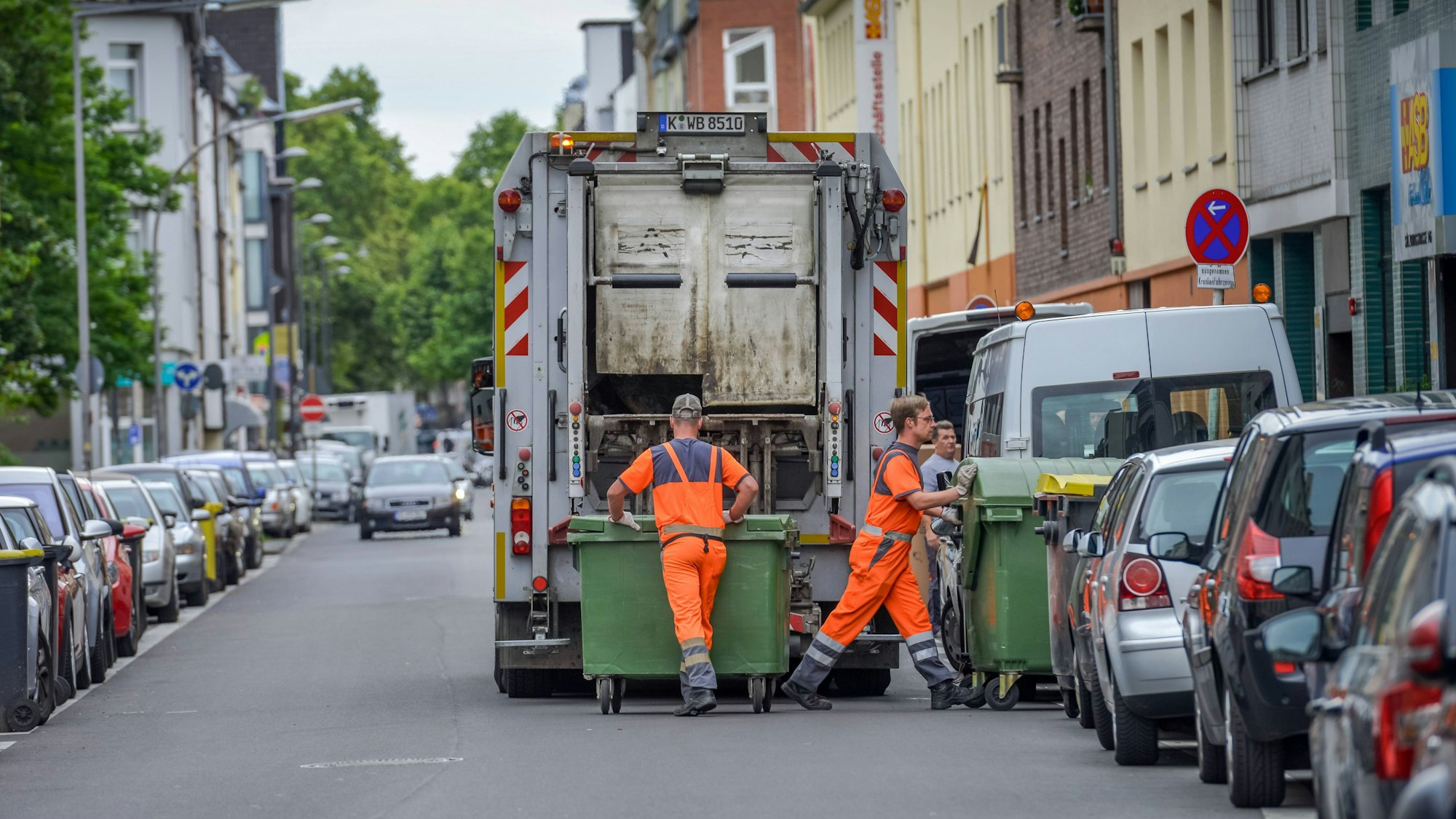 Müllwerker der Kölner Abfallwirtschaftsbetriebe (AWB) bei der Abholung von Müllcontainern.