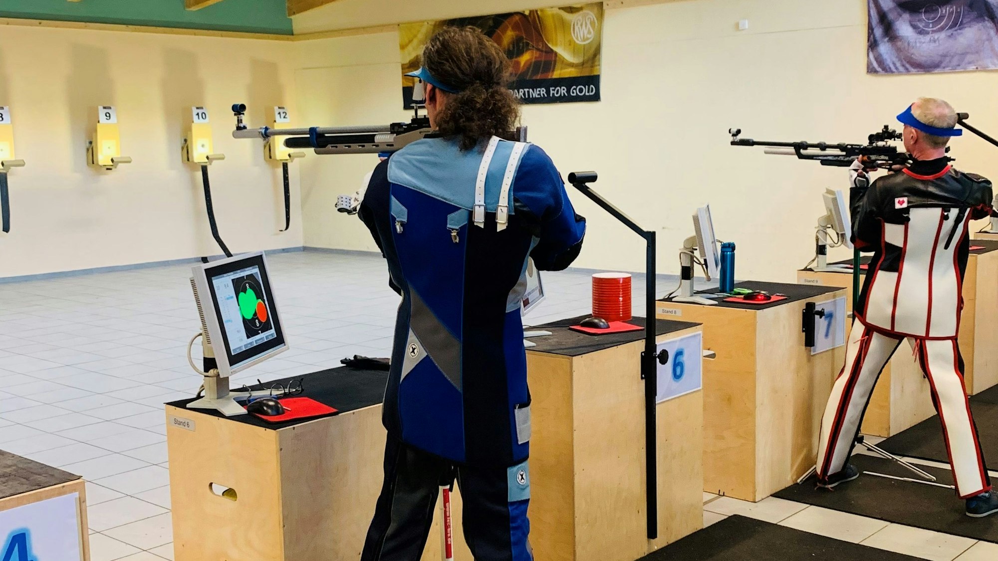 Sportschützen trainieren mit dem Gewehr an einem Schießstand.