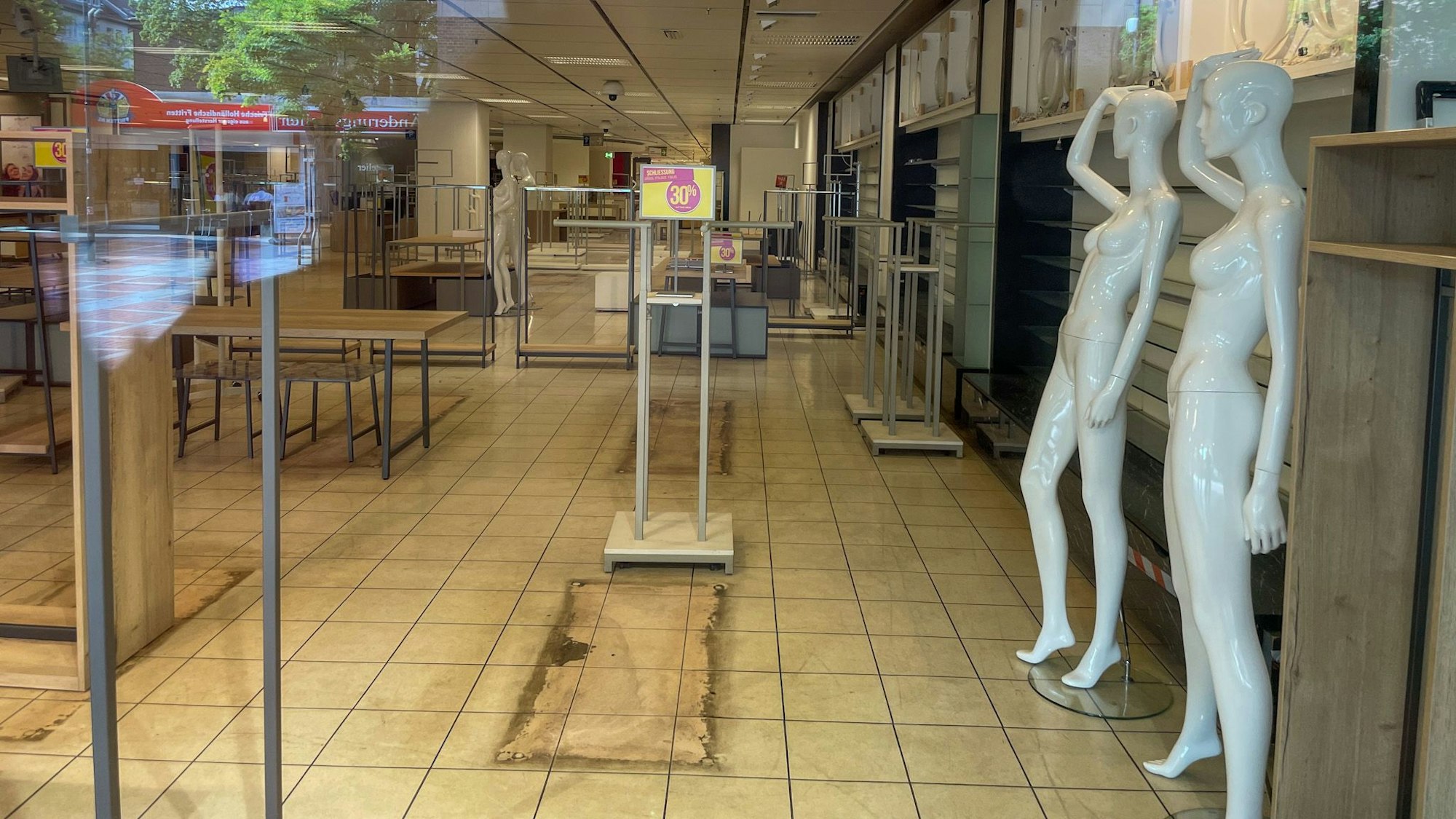Ein Blick durch die großen Fenster im ehemaligen Kaufhof zeigt leere Regale und nackte Schaufensterpuppen.