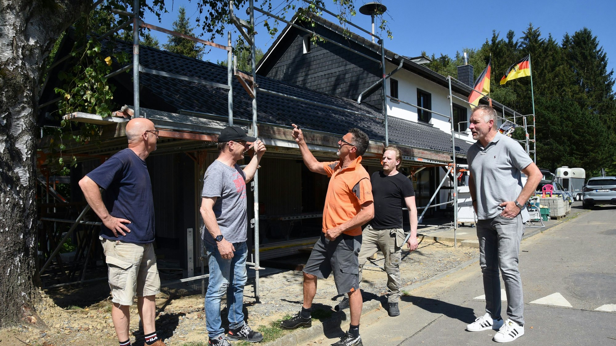 Fünf Männer vor einer Baustelle.