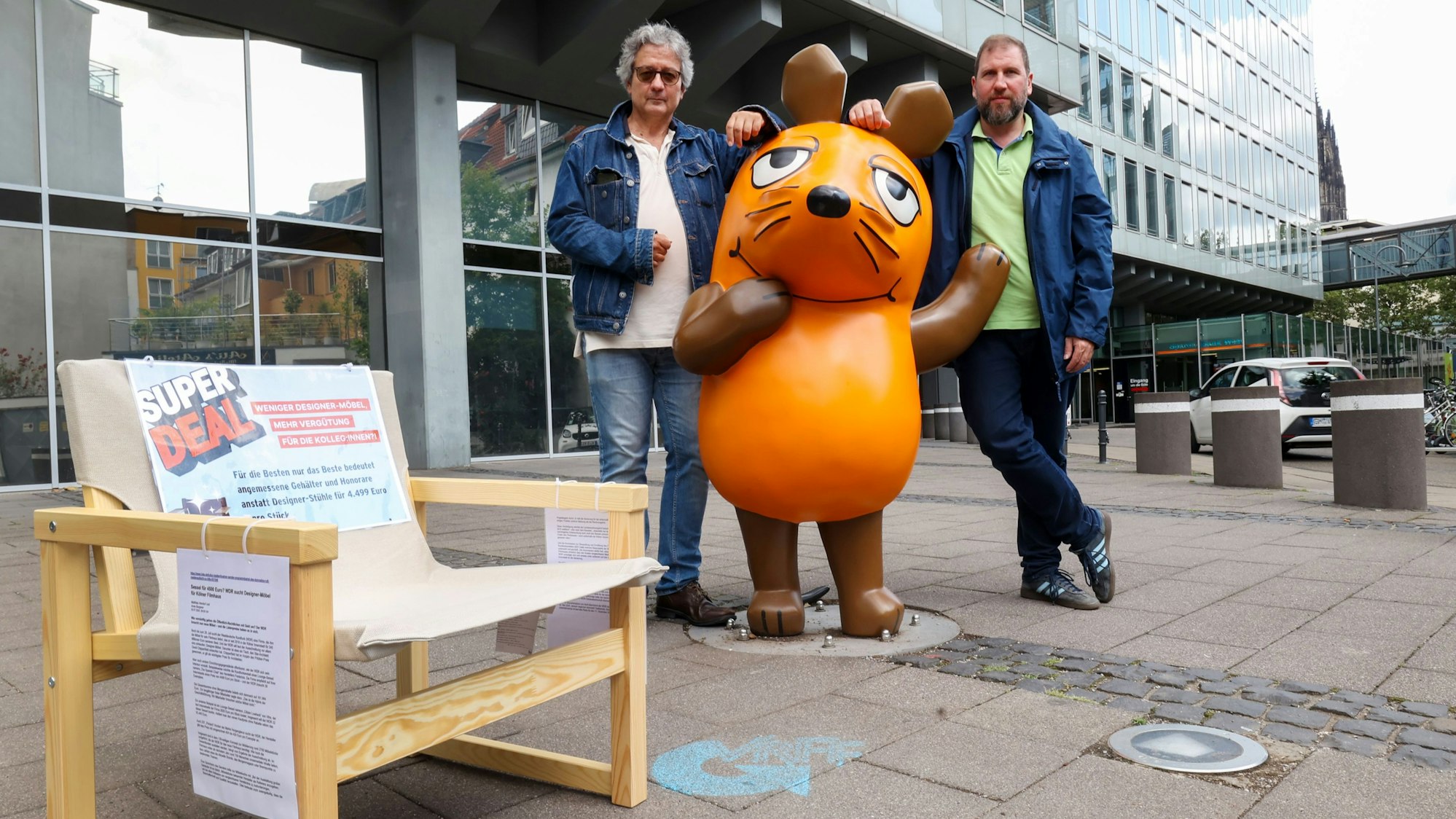 Zu sehen sind zwei Männer, die vor dem WDR-Filmhaus in Köln stehen.