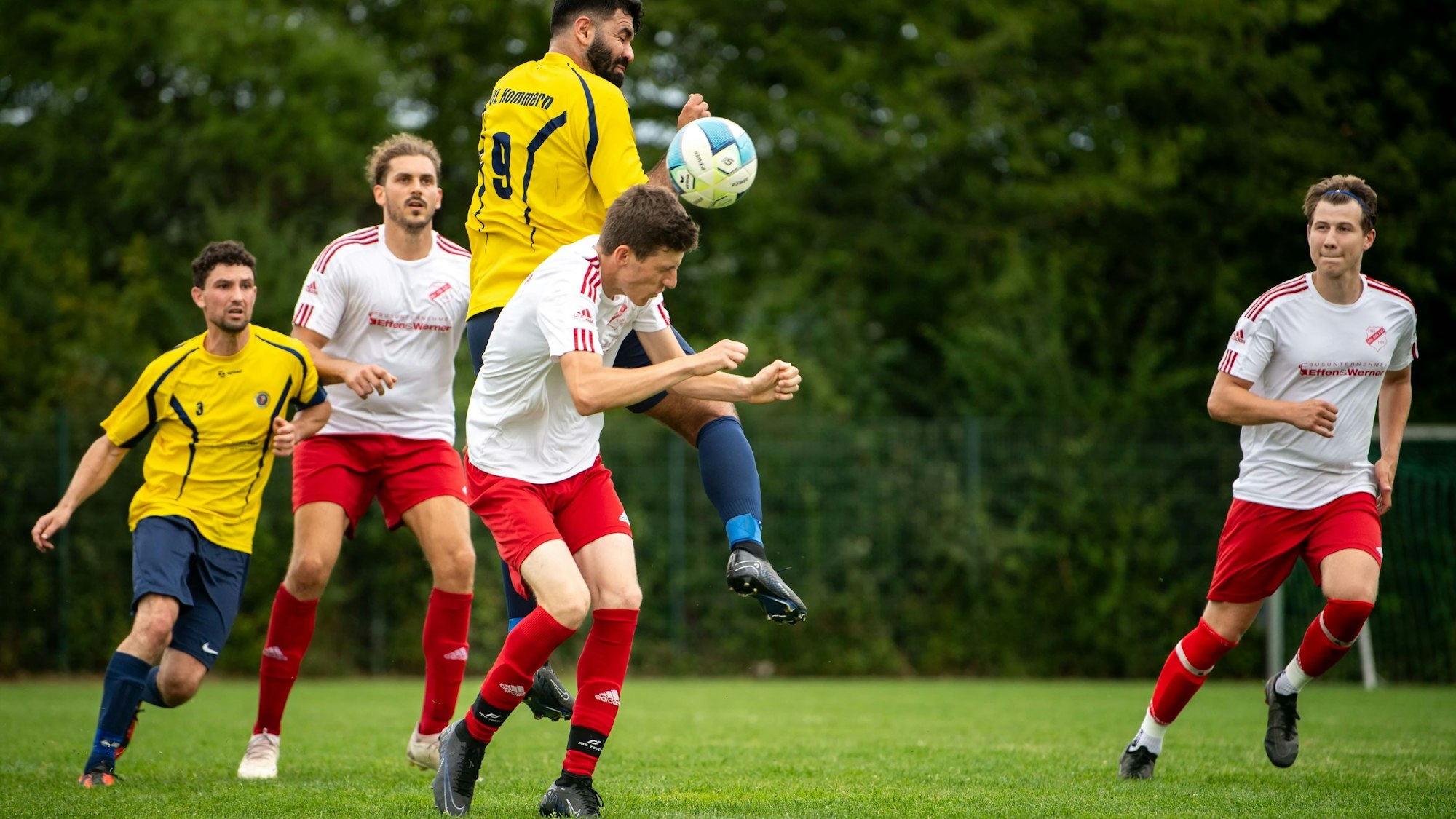 Das Bild zeigt einen Zweikampf nach einem Eckball. Ferhat Alkan springt hoch und klärt den Ball.