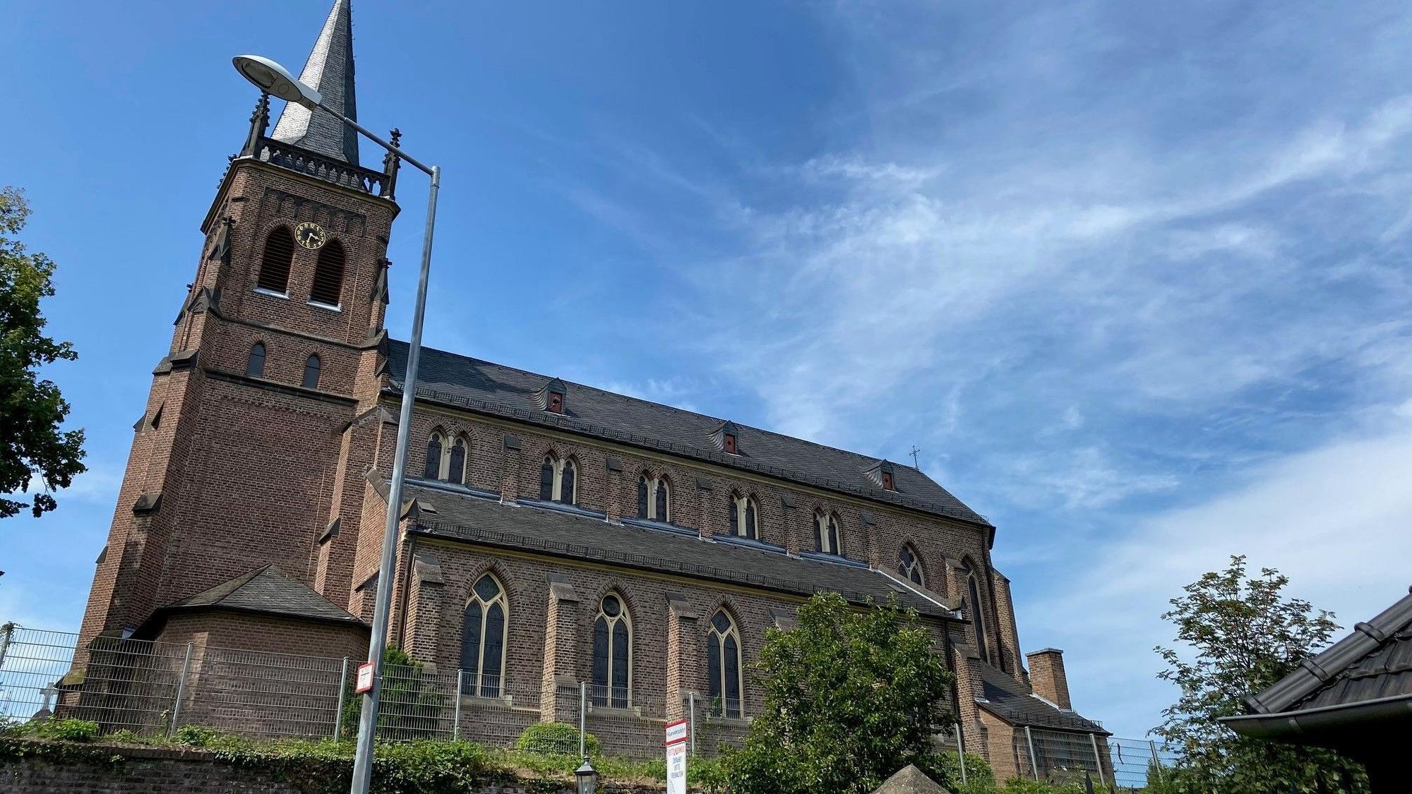 Zu sehen ist eine Kirche vor blauem Himmel.