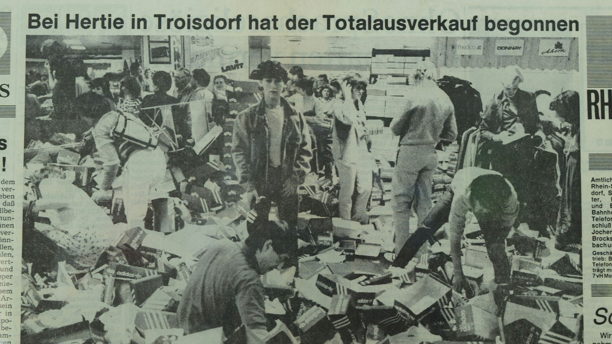 Ein altes Zeitungsfoto zeigt Menschen, die auf einem Berg von Schuhkartons stehen und wühlen.