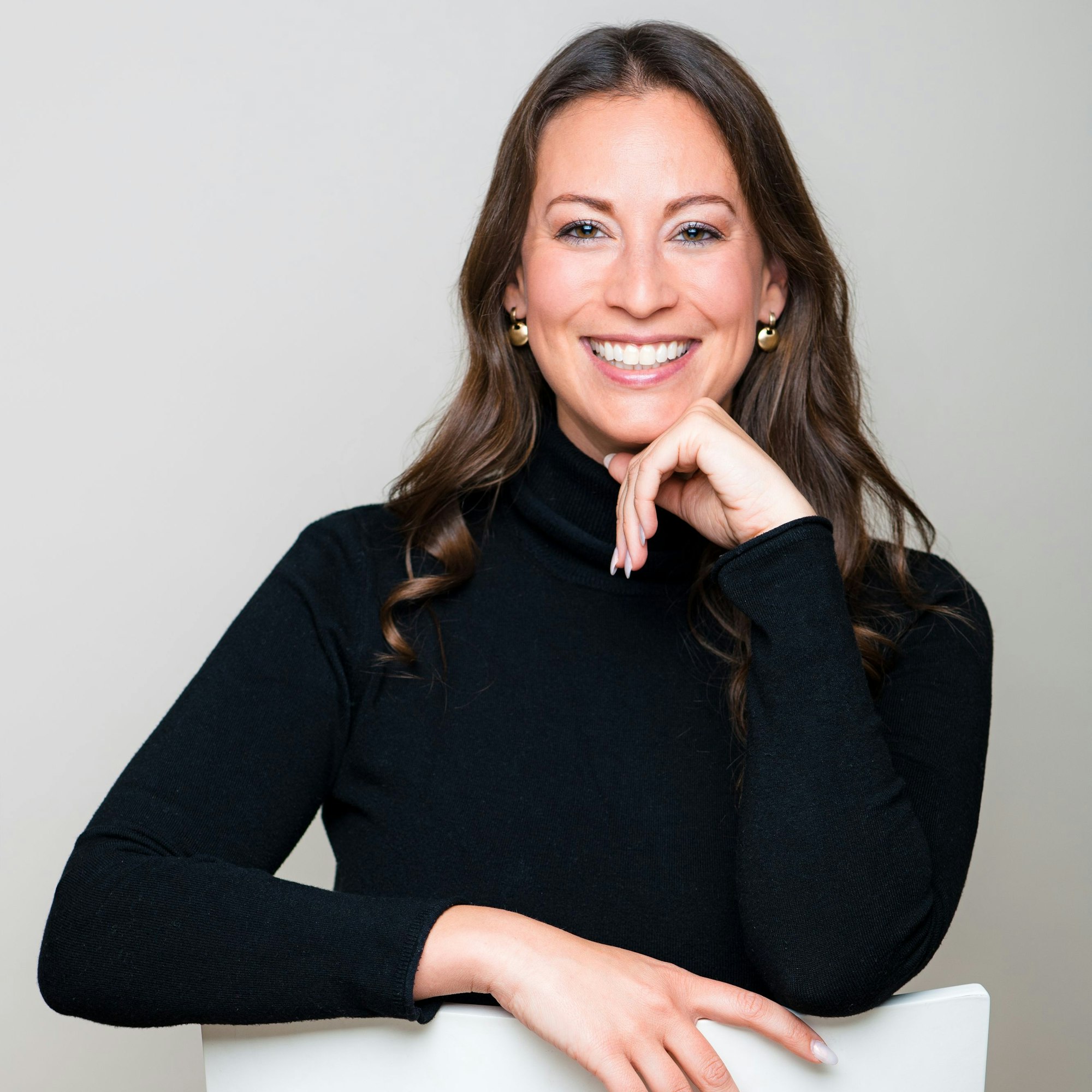 Caroline Bosbach sitzt rücklings auf einem weißen Stuhl.