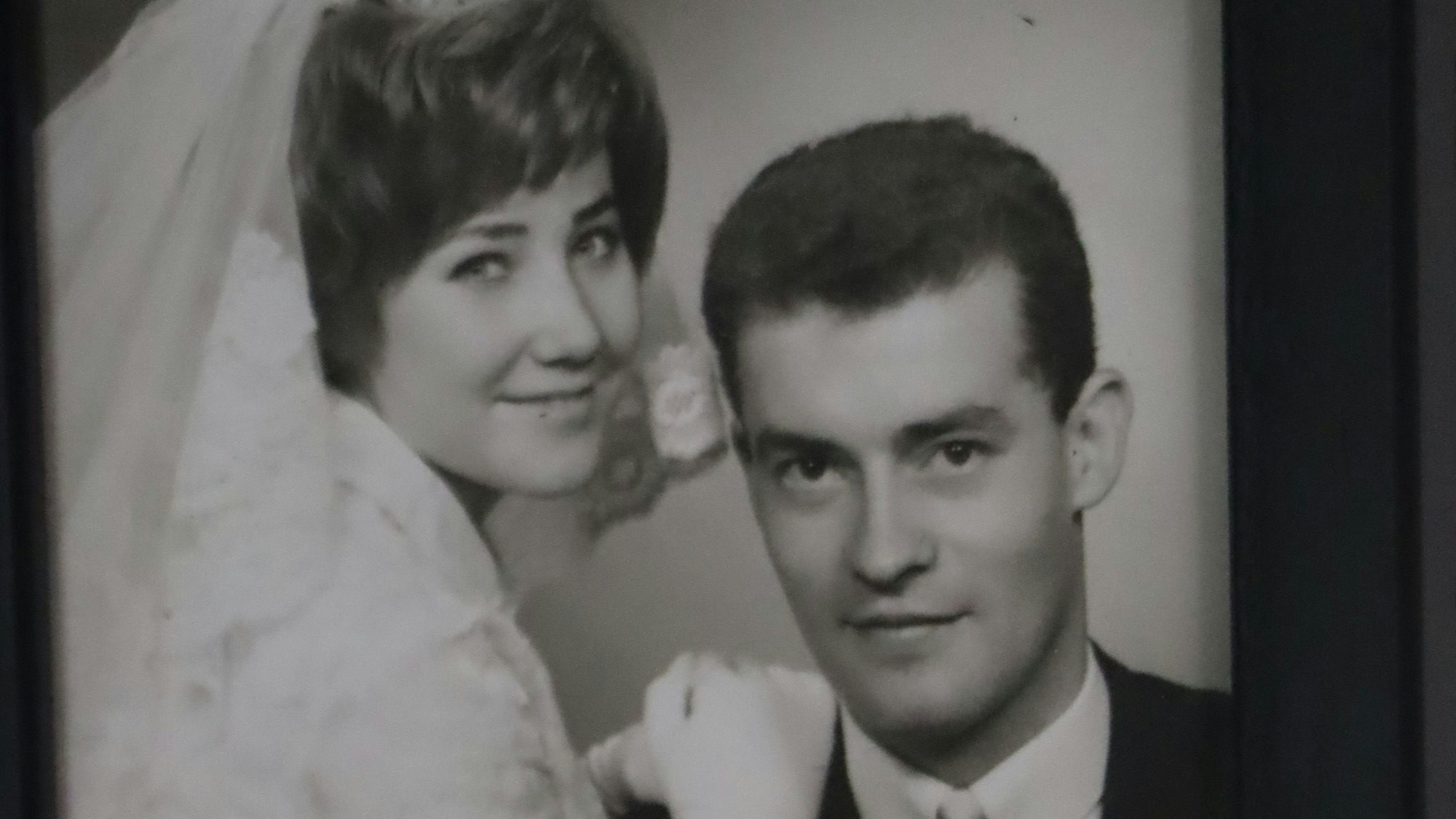 Zu sehen ist ein Brautpaar in schwarz-weiß bei seiner Hochzeit.