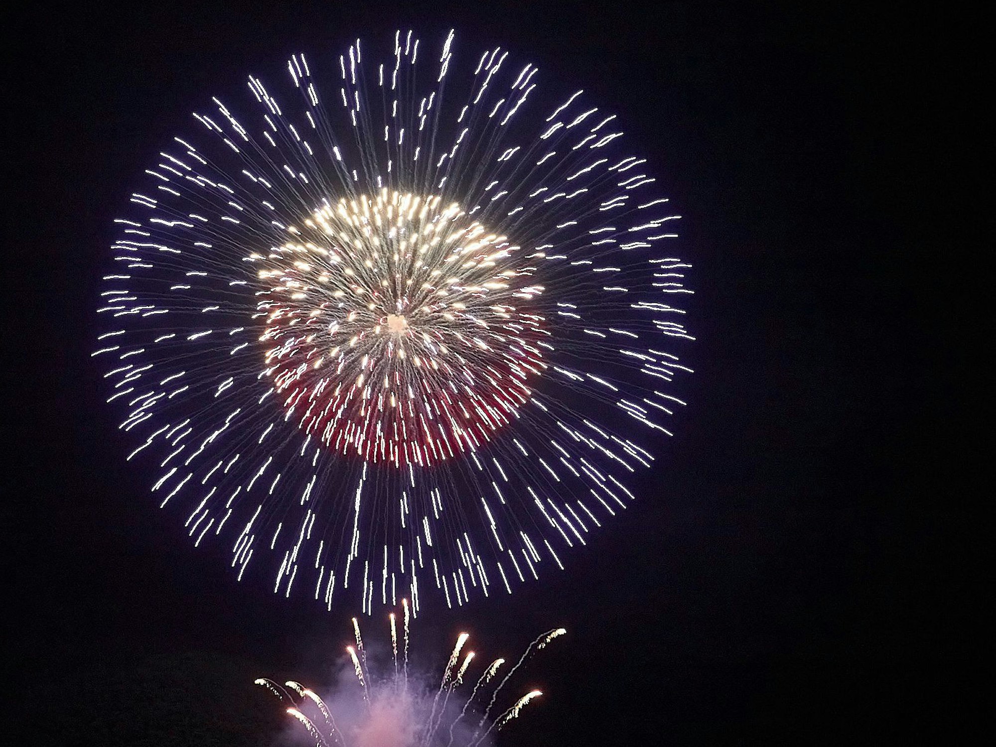 Foto von einer bunten Feuerwerksrakete am Himmel.