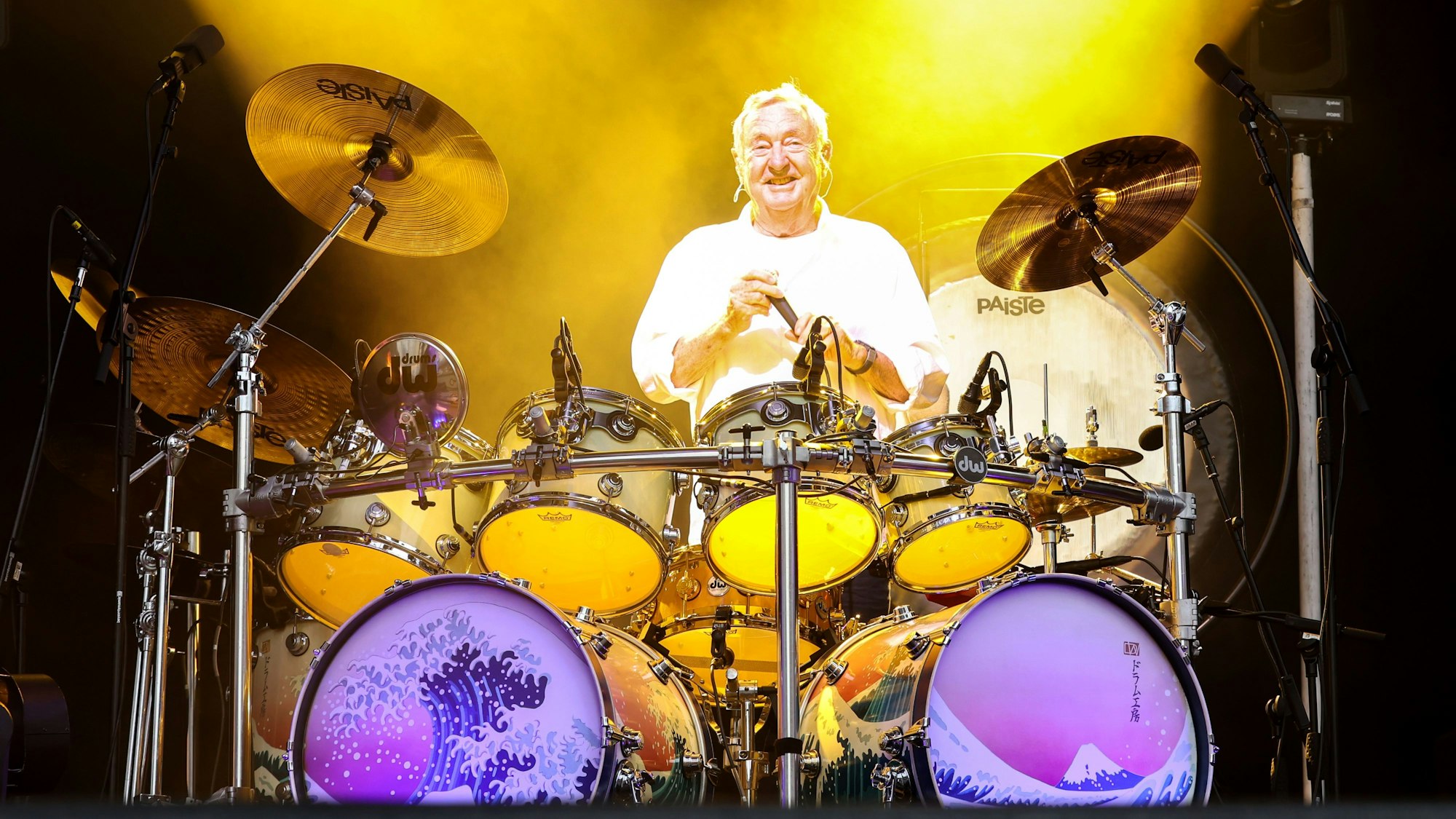 Nick Mason wird von gelben Scheinwerfern bestrahlt.