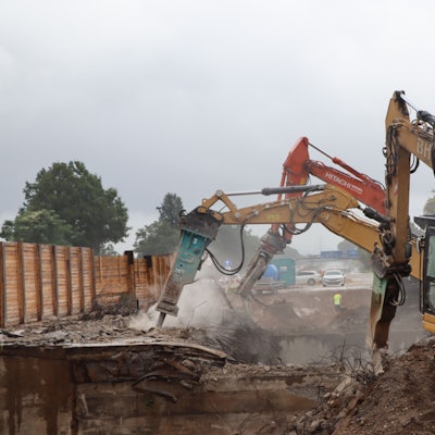 Das Bild zeigt mehrere Bagger, die eine Brücke der A555 bei Wesseling abbaggern.