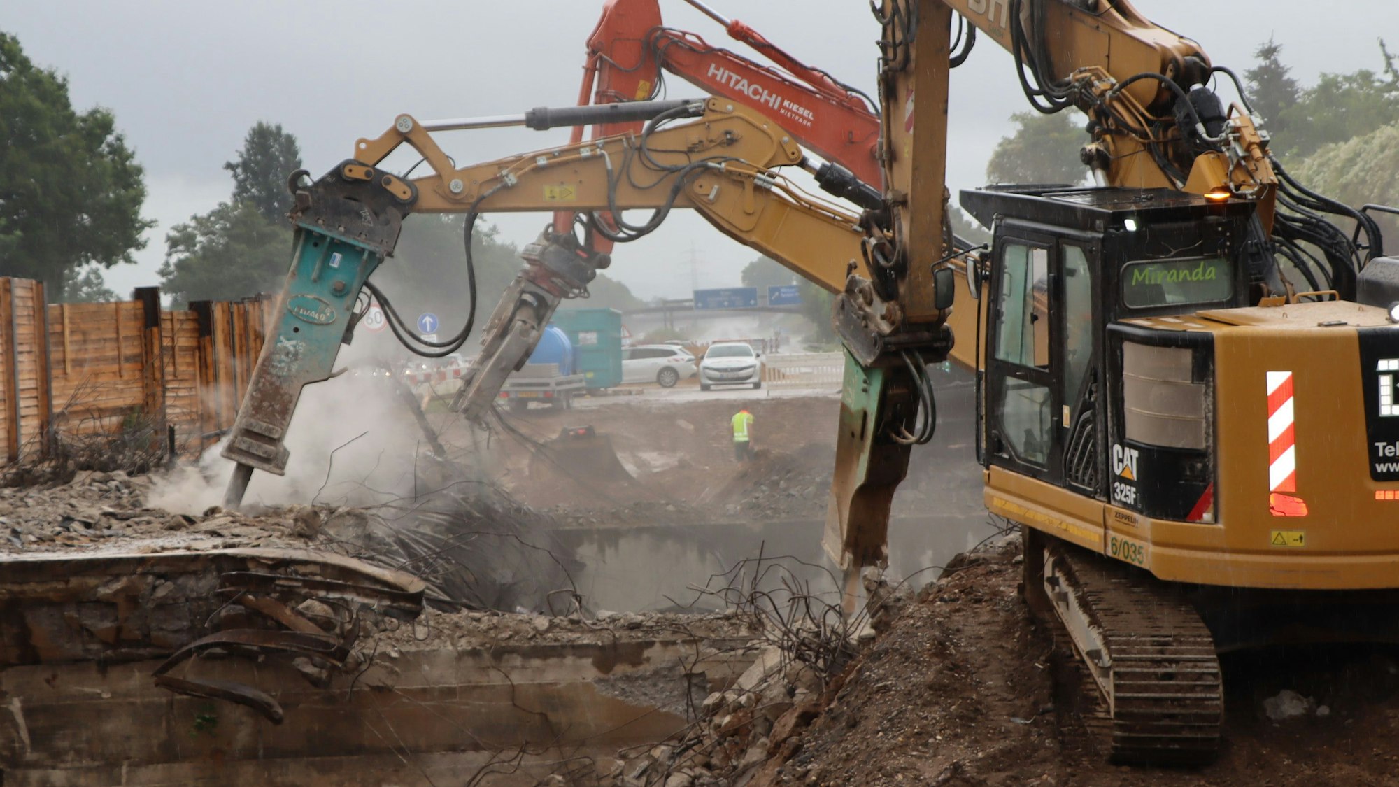 Das Bild zeigt mehrere Bagger, die eine Brücke der A555 bei Wesseling abbaggern.