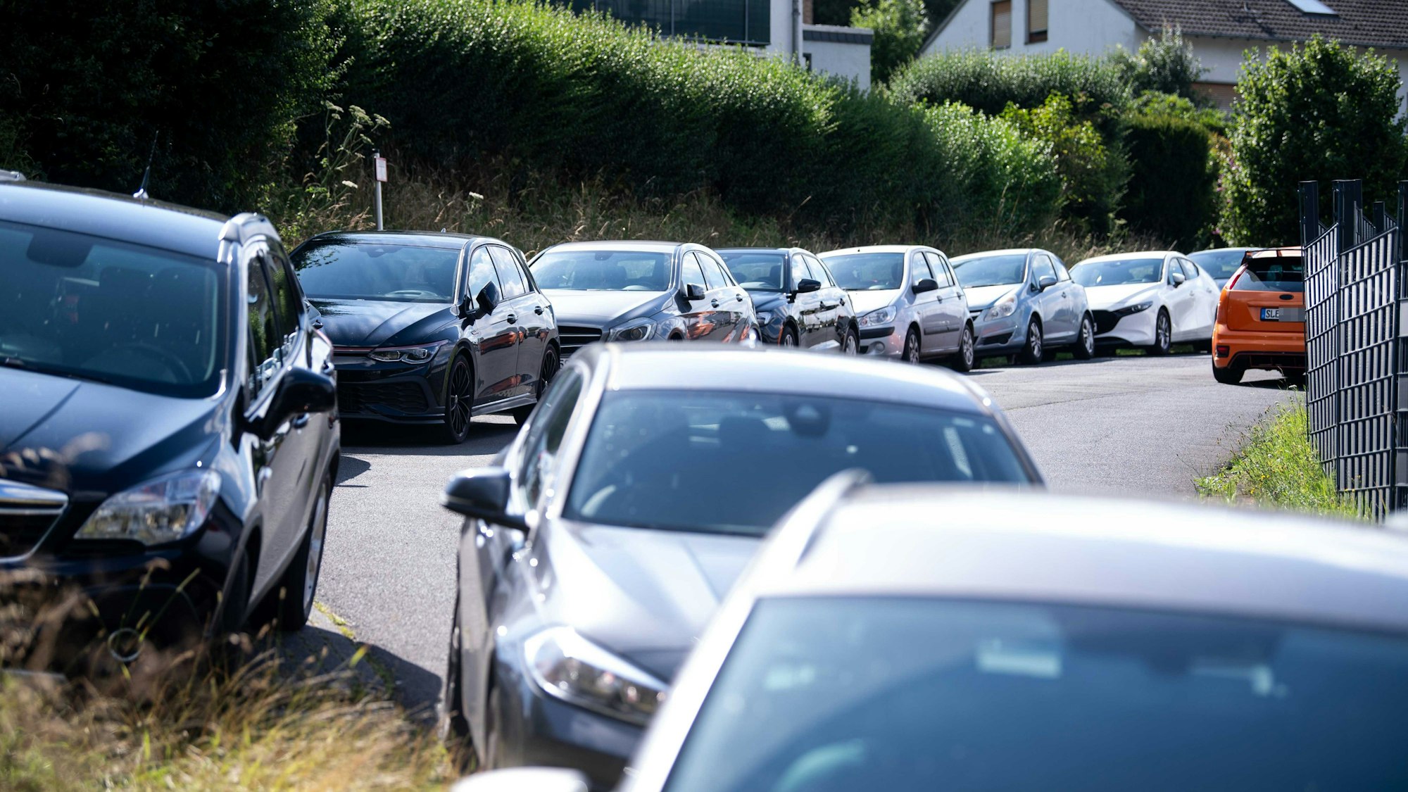 Der Straßenrand ist voll gestellt mit Autos.