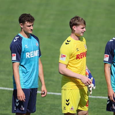 Eric Martel (v.l.), Jonas Urbig und Timo Hübers vom 1. FC Köln warten in St. Veit an der Glan auf den Anpfiff des Testspiels gegen Udinese Calcio.