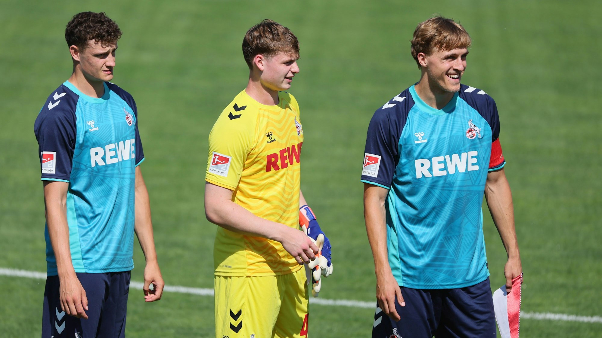 Eric Martel (v.l.), Jonas Urbig und Timo Hübers vom 1. FC Köln warten in St. Veit an der Glan auf den Anpfiff des Testspiels gegen Udinese Calcio.