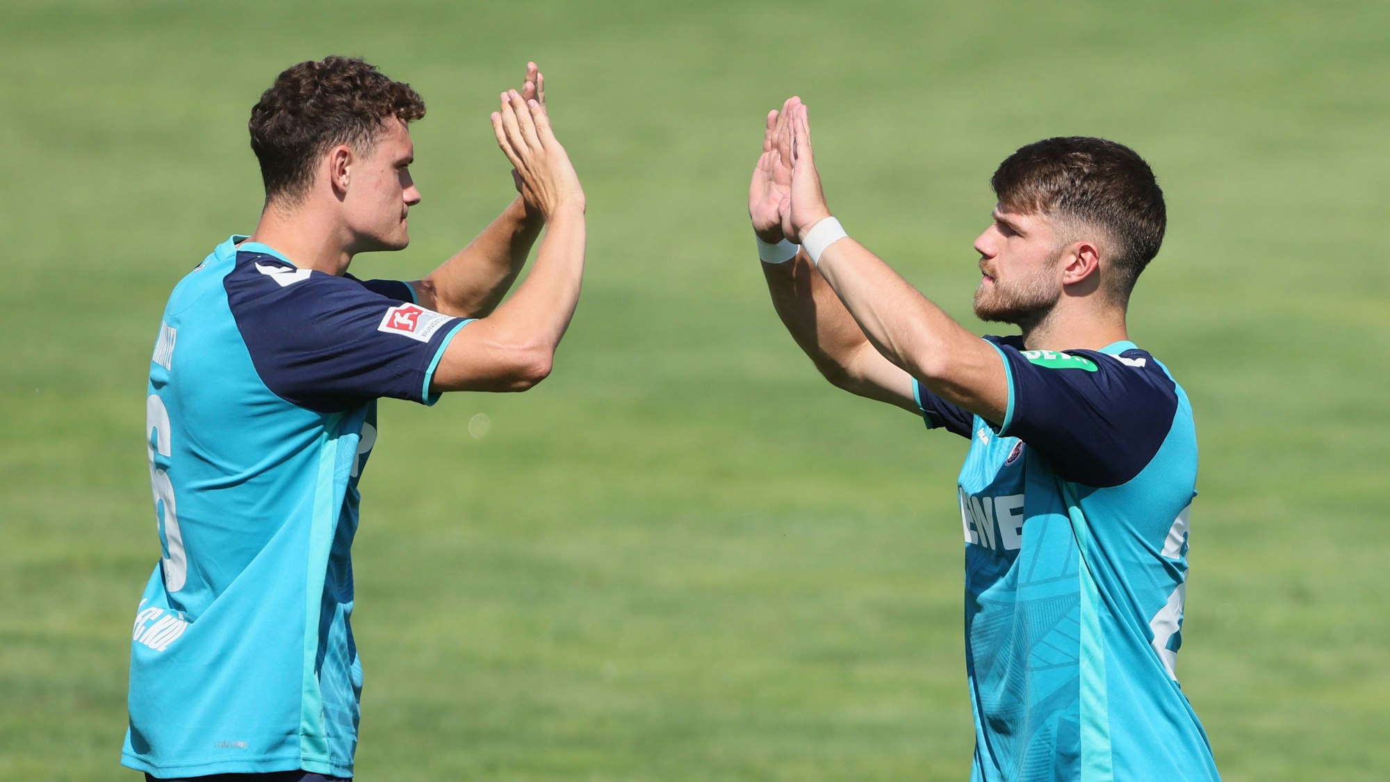 Eric Martel (l.) und Jan Thielmann vom 1. FC Köln klatschen sich nach einem Tor im Trainingslager in Österreich ab.