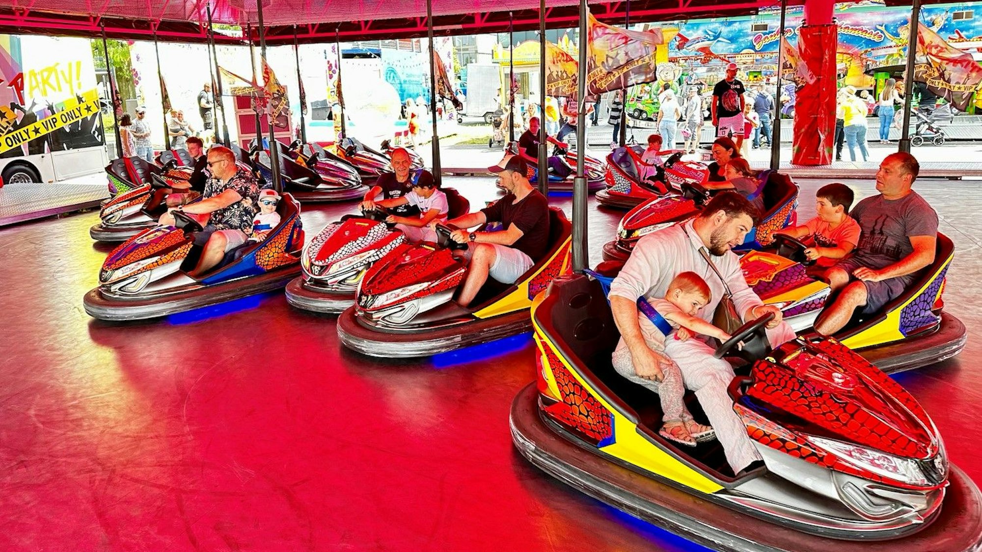 Erwachsene und Kinder im Autoscooter auf einer Kirmes