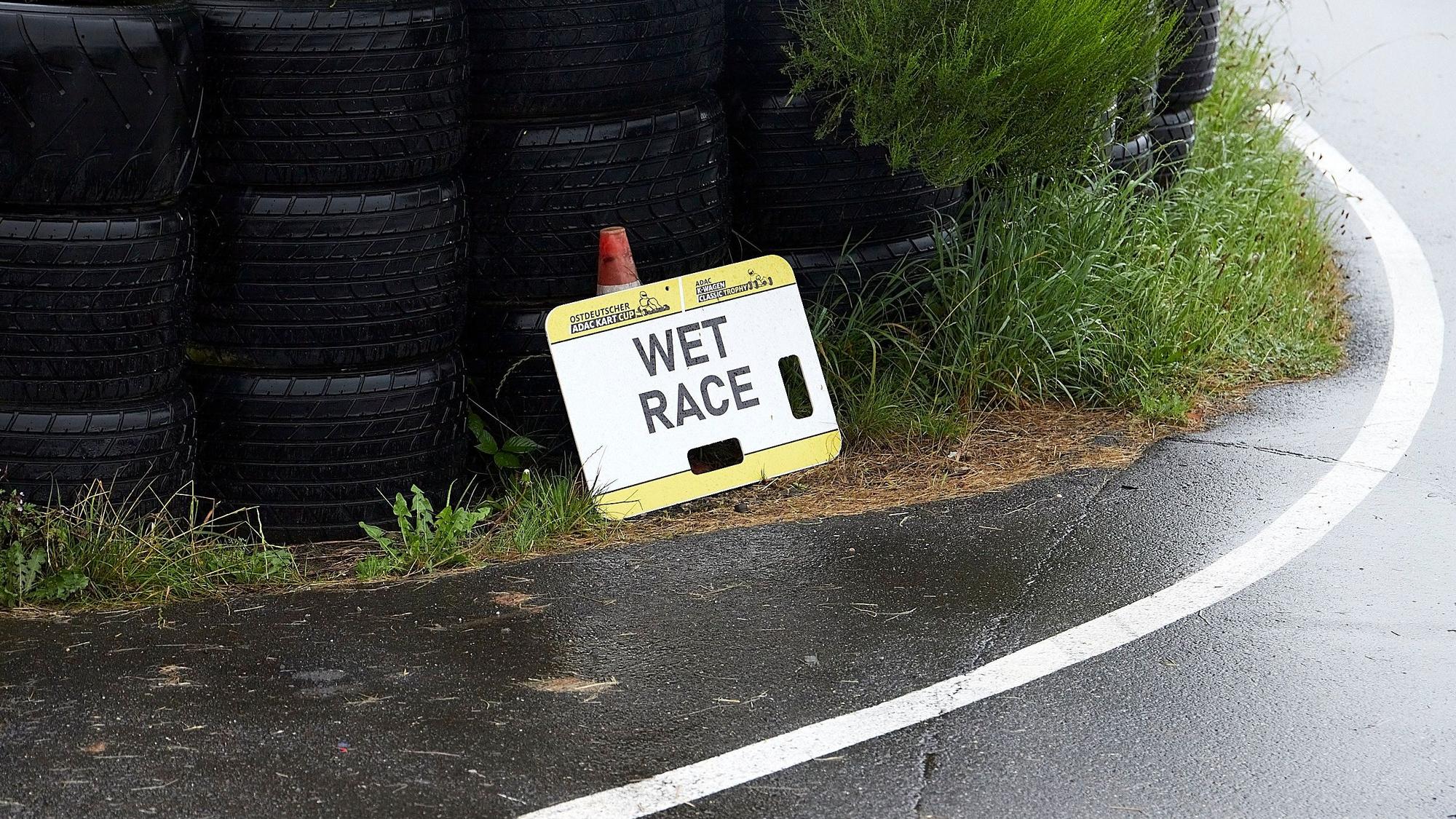 Ein Schild mit der Aufschrift Wet Race steht an der Strecke.