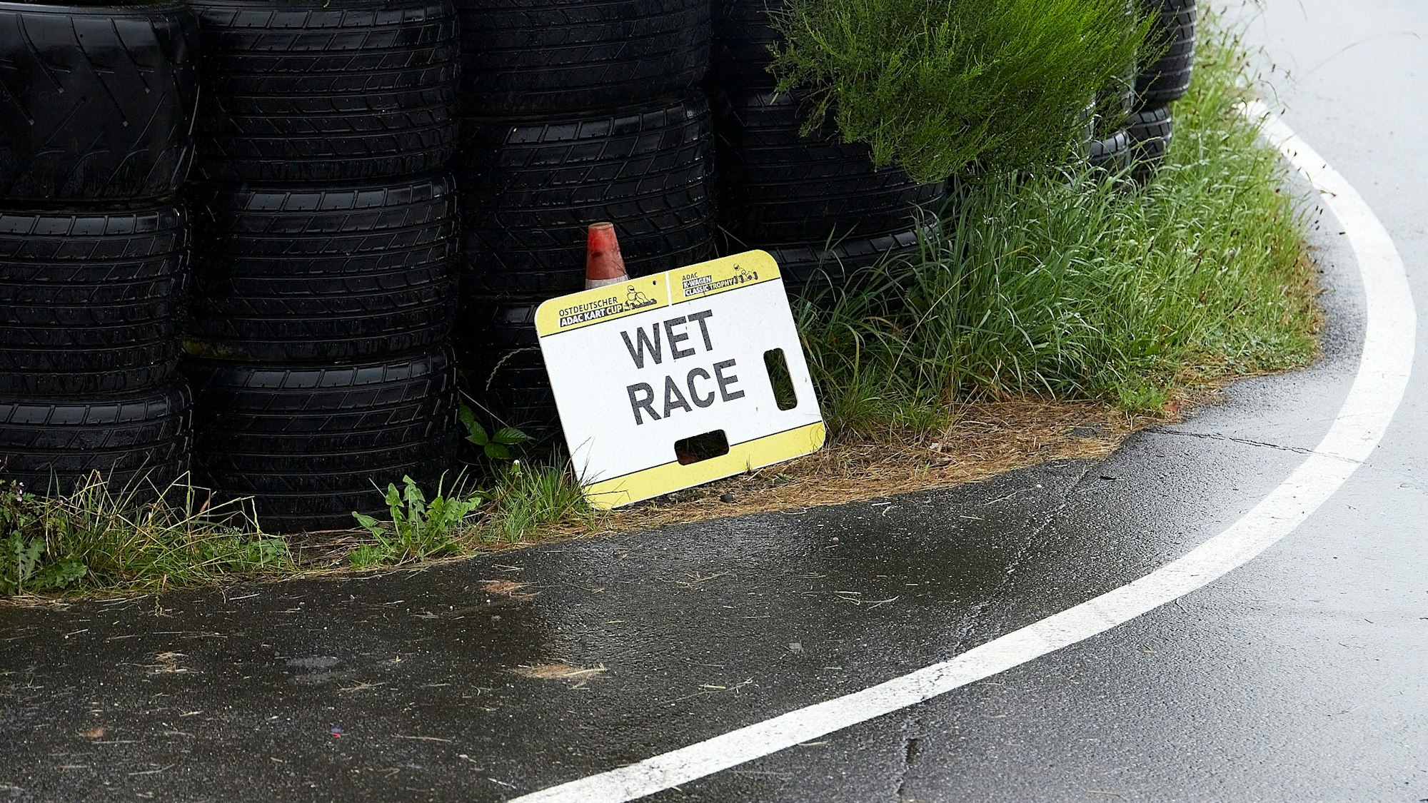 Ein Schild mit der Aufschrift Wet Race steht an der Strecke.