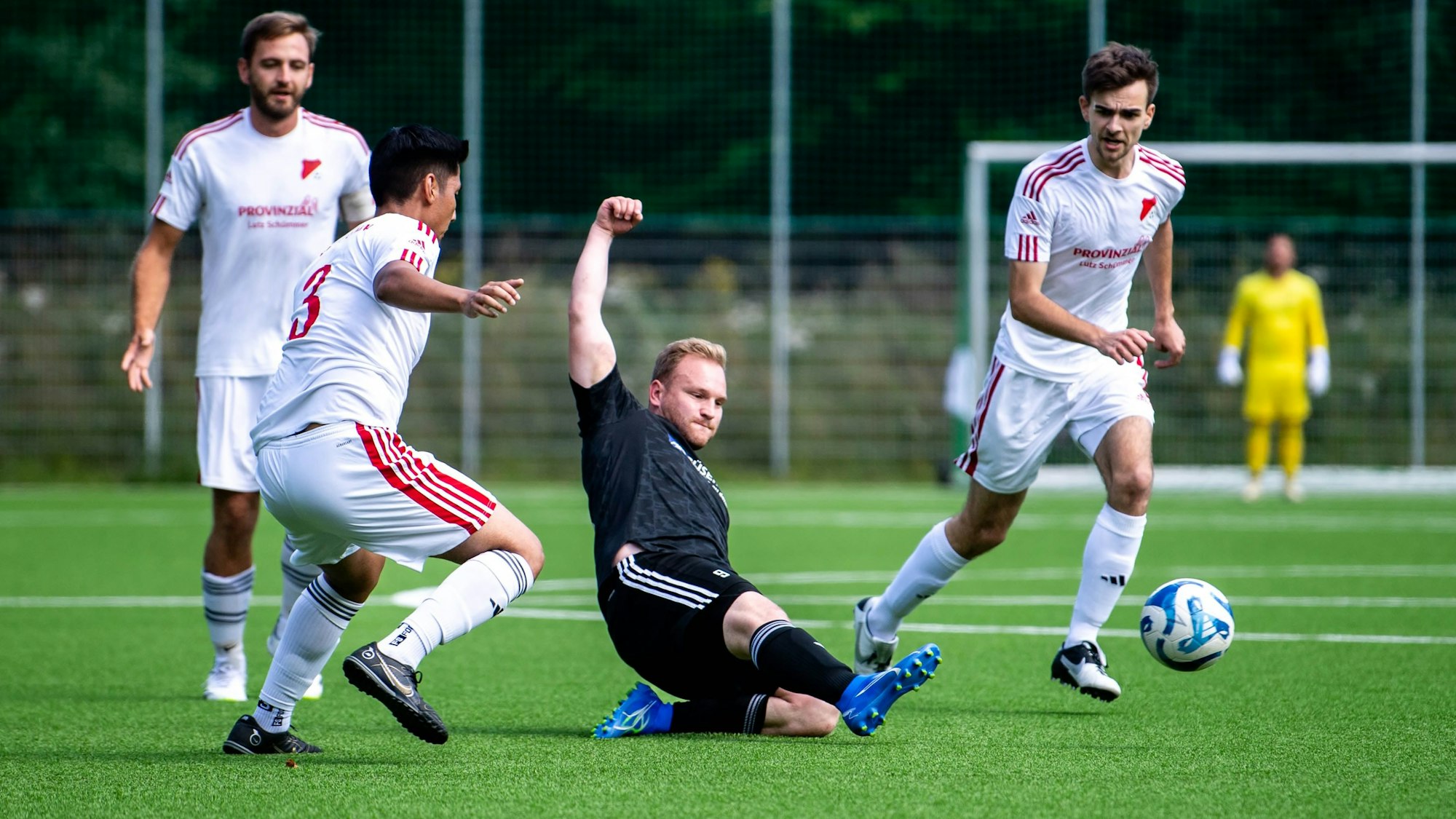 Das Bild zeigt Nierfedls Stürmer Sven Pohl, der den Ball vor drei Gegenspielern weggrätscht.