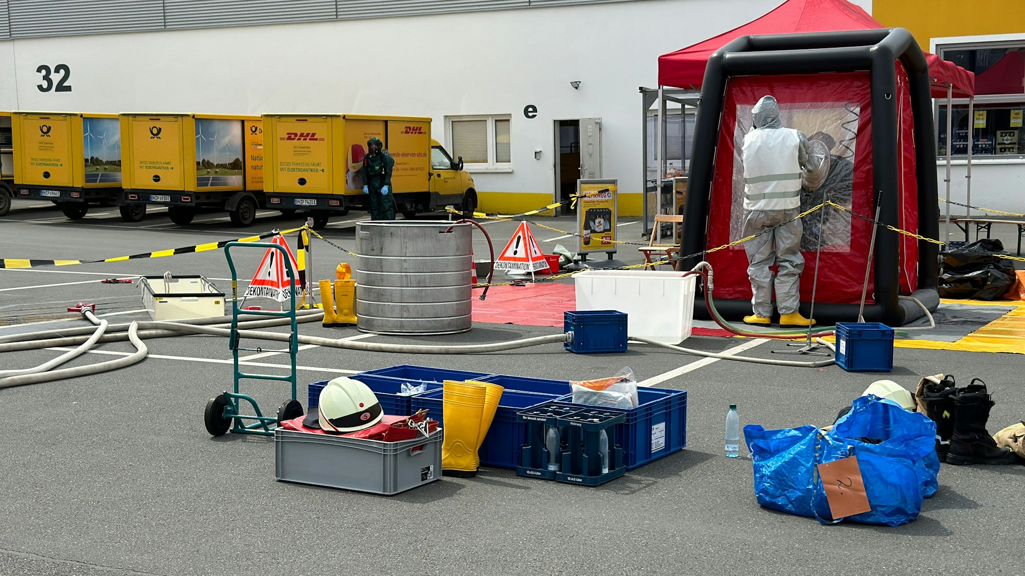 Rettungskräfte stehen am DHL-Verteilzentrum und untersuchen den Stoff.