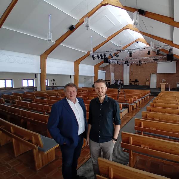 Zwei Männer in einer großen leeren Kirche.