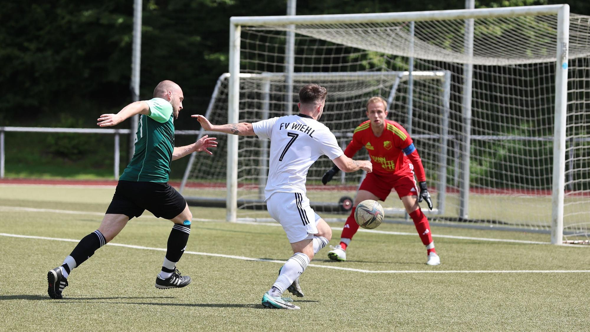 Der Wiehler Spieler mit der Nummer 7 läuft mit dem Ball am Fuß auf den Bergneustädter Torhüter zu.